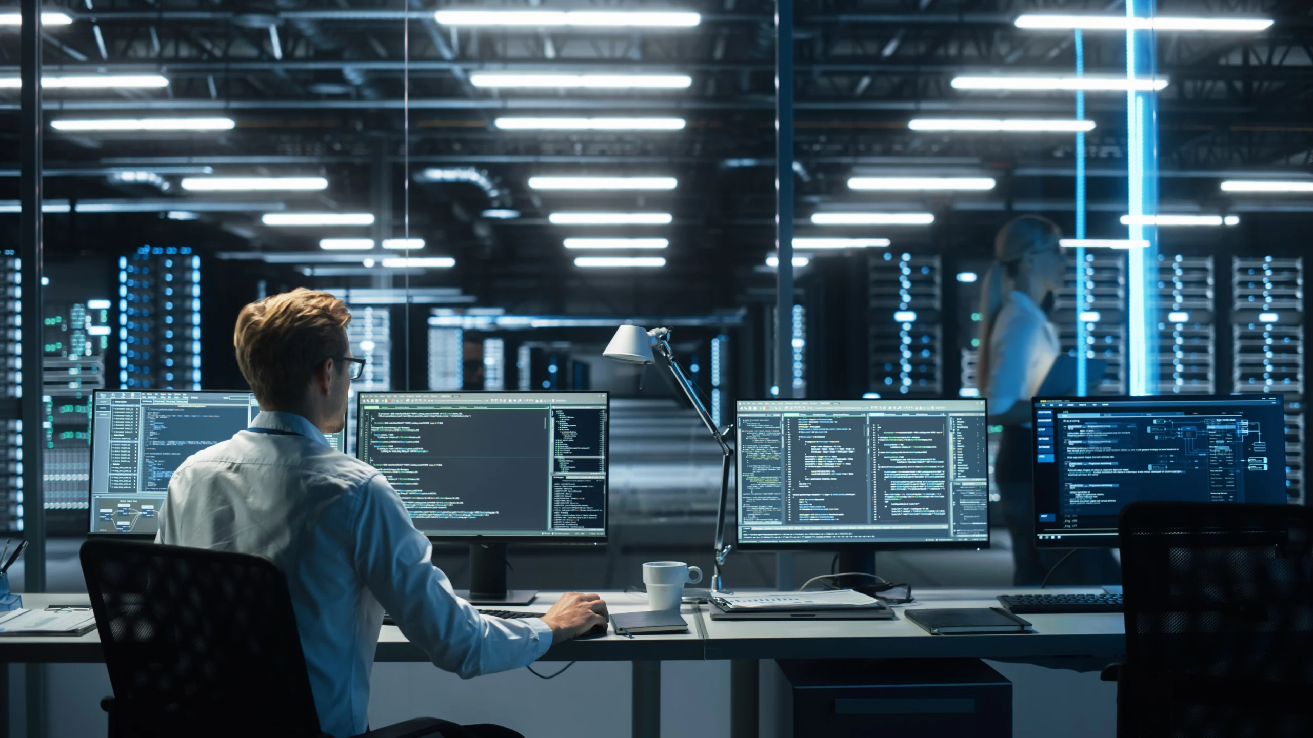 man on a computer in a server room